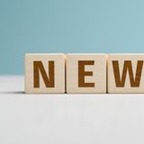 Wooden letters form the word "NEWS" on a light background.