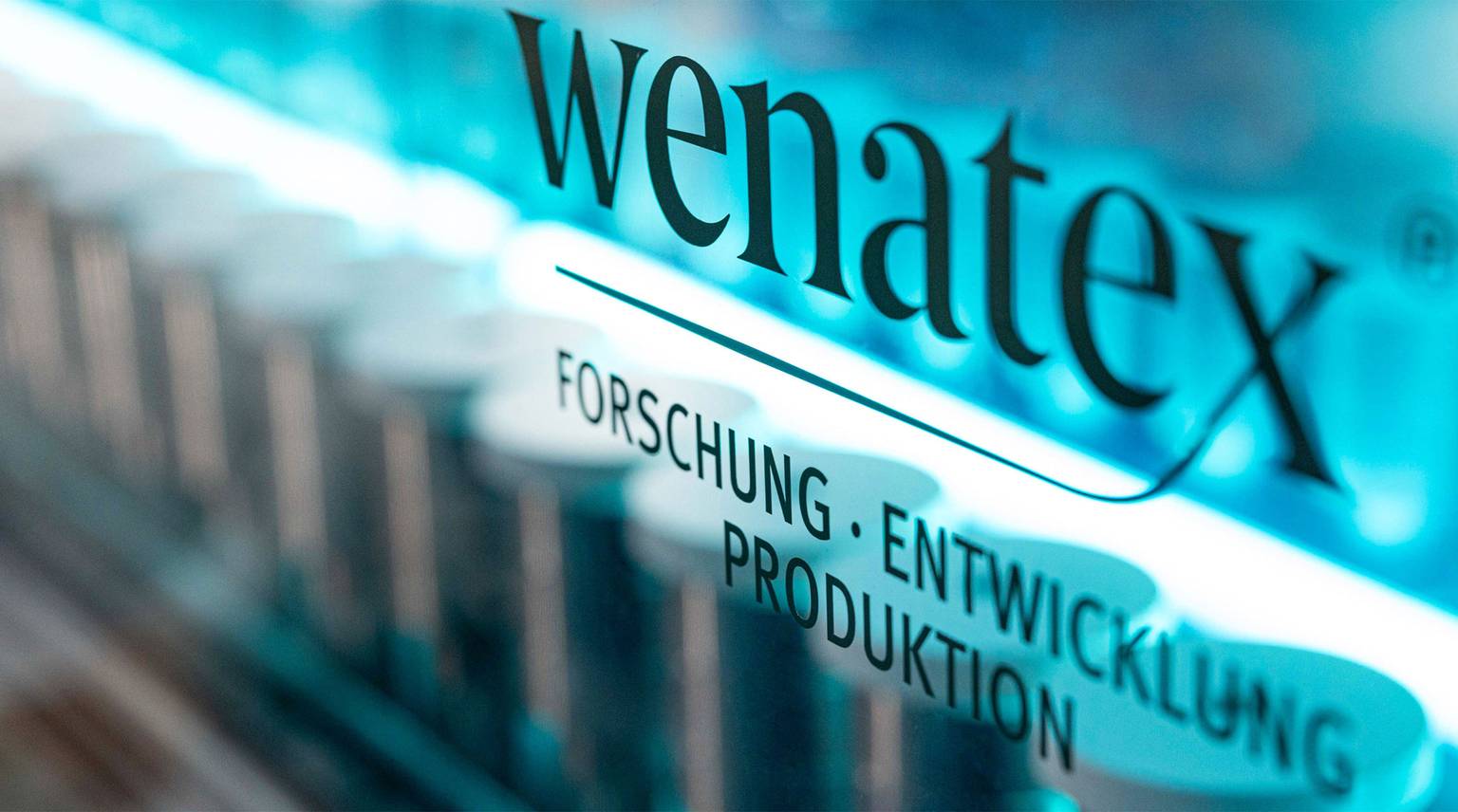 Wenatex logo highlighting research, development, and production in a modern laboratory setting.
