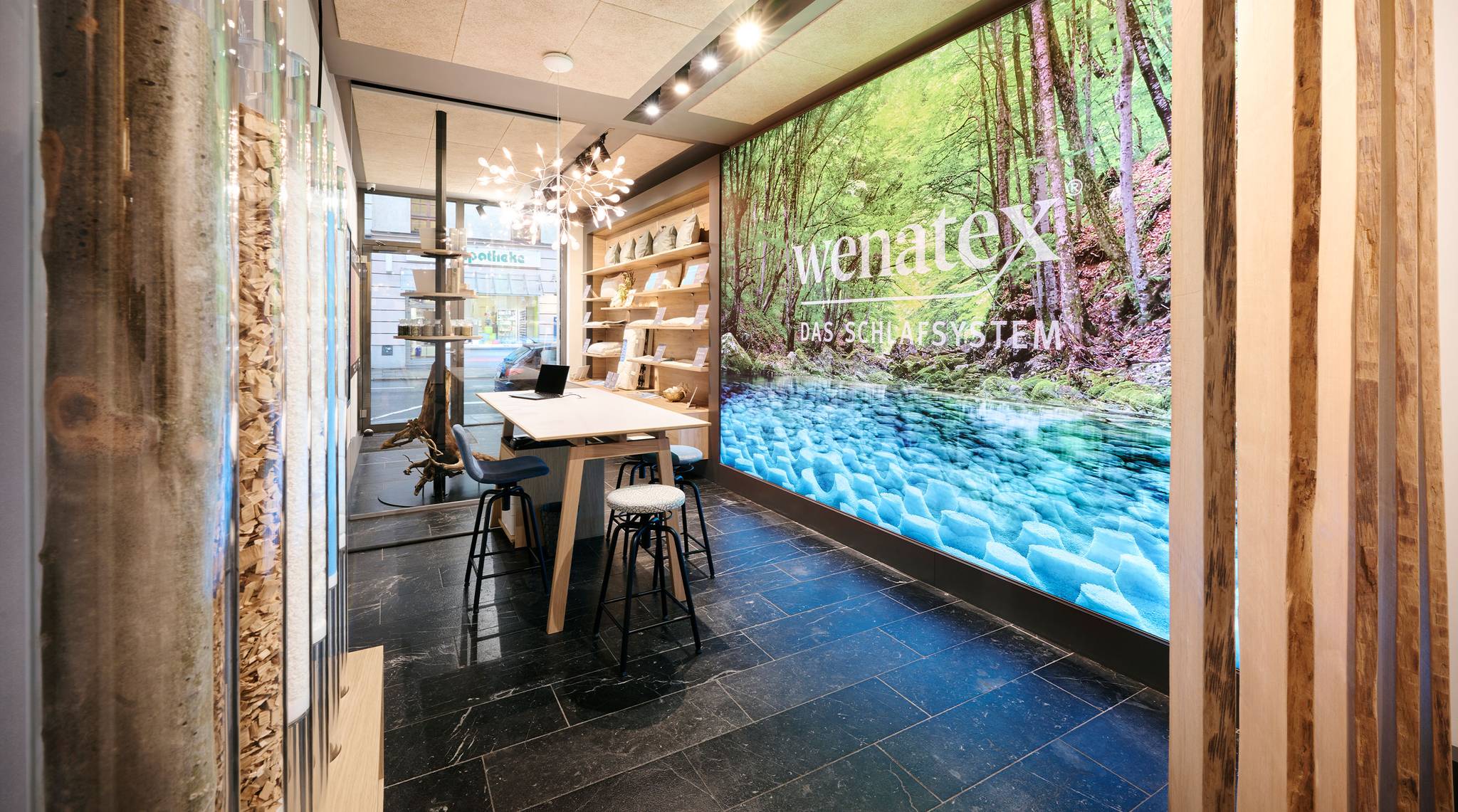 Interior view of a modern room featuring wooden shelves, a table, and a large nature landscape wall mural.