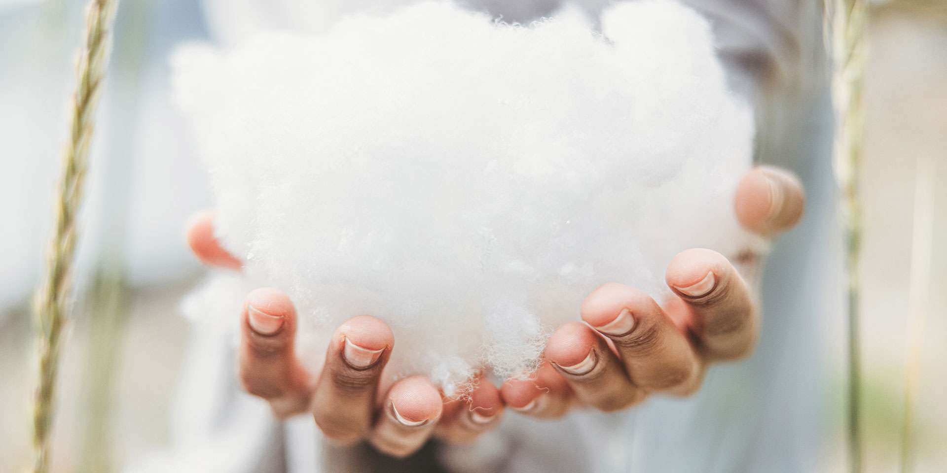 Hands holding a soft, white filling suitable for sleep comfort.
